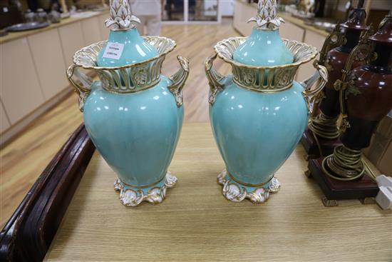 A pair of Ridgway turquoise and gilt ground two handled lidded vases, each painted with panels of garden flowers, height 42cm